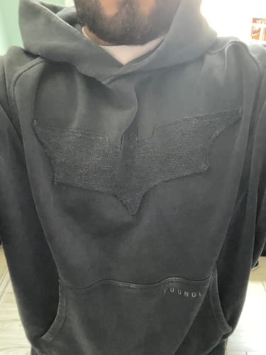 Customer wearing the Batman Stealth Hoodie, showing the dark washed finish and raised tonal bat emblem on the chest.