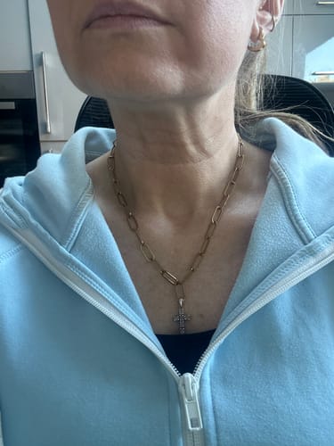 Reviewer wearing the gold paperclip chain necklace with their own cross pendant attached.