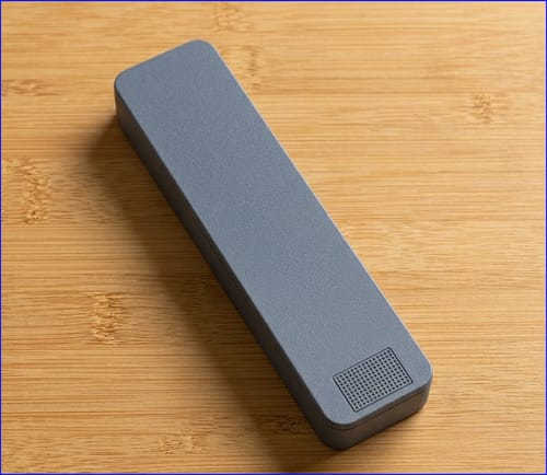 Customer's gray aluminum Weekly Case resting on a light wood surface.