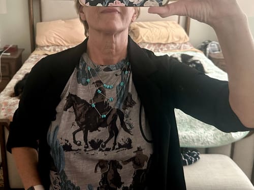 Close-up of a reviewer wearing the Western Print Tunic Top layered under a black jacket with a turquoise necklace.