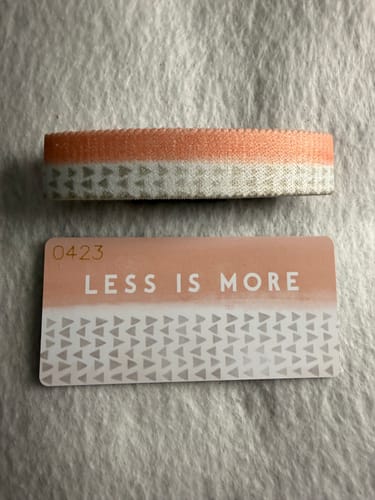 Customer's Less Is More Bracelet and its matching collector's card laid out on a light, textured surface.