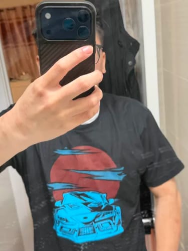 Reviewer taking a mirror selfie to show the blue Supra graphic on their black Solar Drift Shirt.