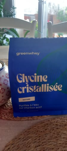 Client montrant le sachet bleu de Glycine cristallisée posé sur une table.