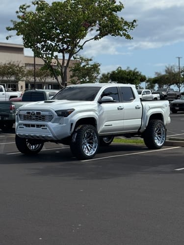 Customer's white Toyota Tacoma showing the wide stance from the installed 1.5 inch wheel spacers.