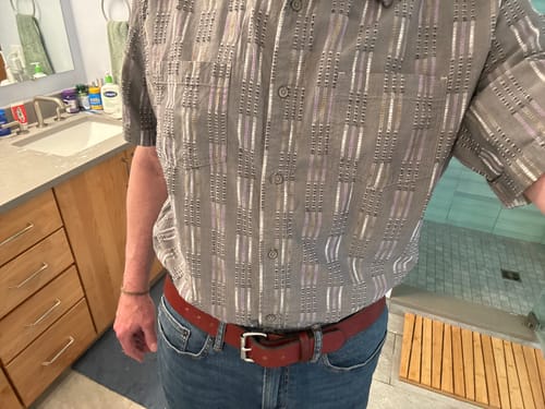 Customer wearing The Gunner brown leather belt with a silver buckle and blue jeans.
