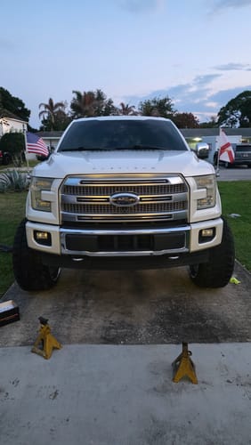 Customer's white Ford truck with large aftermarket wheels, shown after installing the chrome spike lug nuts.