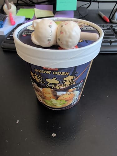 Customer's Meow Oden meatball skewer figurine with a matte finish, displayed on its packaging cup.