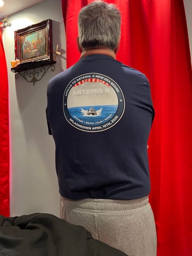 Reviewer wearing the navy blue Apollo To Artemis t-shirt, showing the large Artemis II graphic on the back.