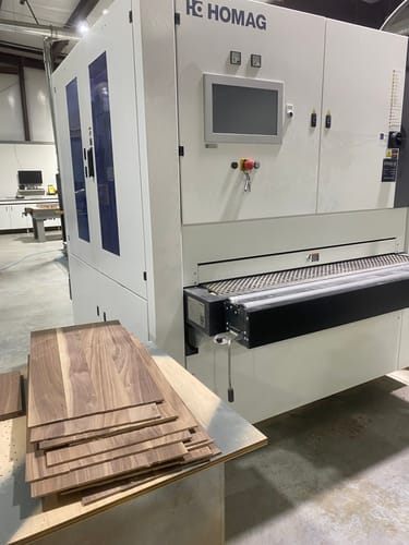 Reviewer's sanded walnut panels next to the wide belt sander using the cloth sanding belt.