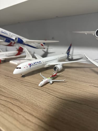 Reviewer's HERPA ROYAL AIR MAROC 737MAX8 model airplane on a wooden shelf next to other larger models in their collection.