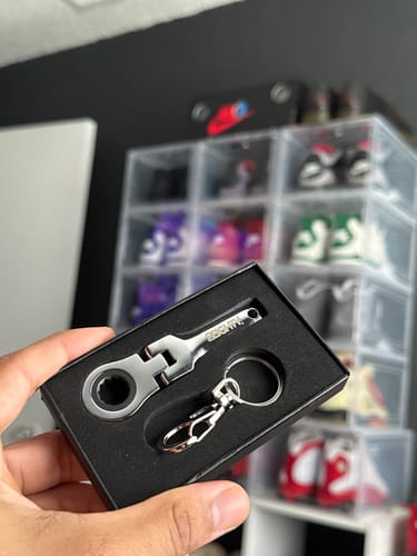 Customer holding the open box showing the 80Eighty® 10mm Wrench Keychain and keyring nestled in the packaging.