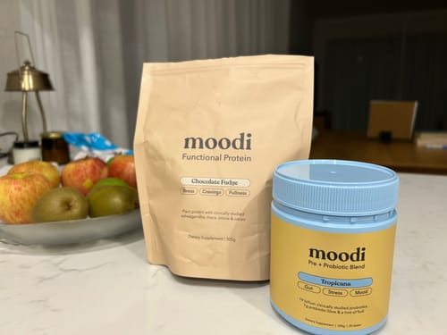 Reviewer's Chocolate Fudge protein bag from the Indulgence Protein Bundle on a kitchen counter next to another product.