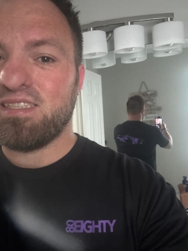 Reviewer takes a mirror selfie to show the front and back of the black Limited Edition DCG88 Shirt.