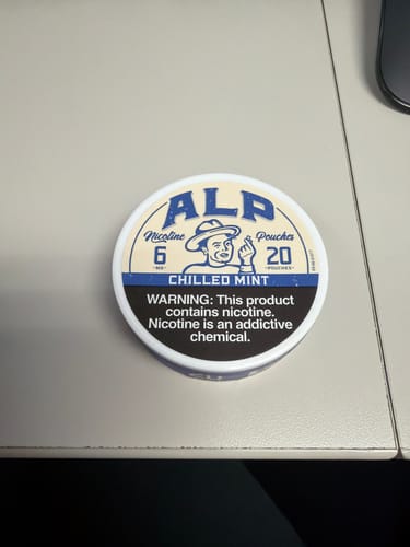 Customer's can of ALP Chilled Mint Nicotine Pouches sitting on a light-colored desk.