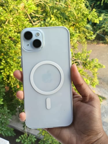 Customer holds an iPhone 15 Plus with the clear Anti Yellow Magsafe Case, showing its white magnetic ring.
