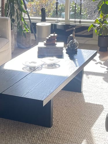 Kunde viser sitt salongbord dekket med mørk Blackwood kontaktplast i en stue.
