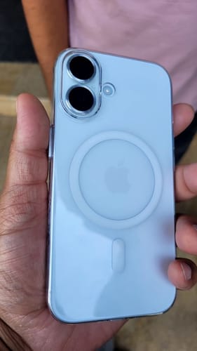 Customer holding a light blue phone in the Anti Yellow Magsafe Clear Case, showing the back and magnetic ring.
