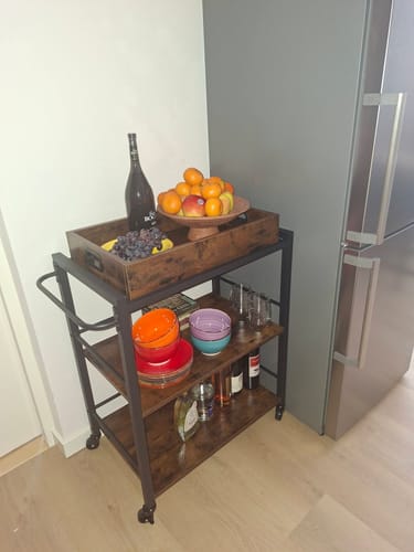 Recensents stevige keukentrolley in de keuken, gevuld met fruit, drankjes en servies.