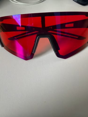 A customer's pair of red shield-style HyperX glasses on a white surface.
