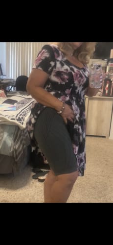 Customer lifts a dress to show the dark, ribbed 3D Anti-Cellulite Short Leggings being worn underneath.