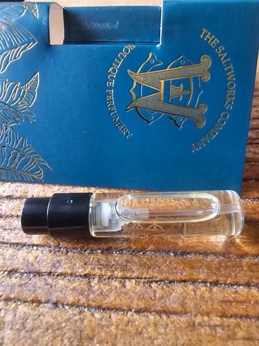 Customer's small sample vial of Kami Tonka fragrance resting in front of its blue and gold box.