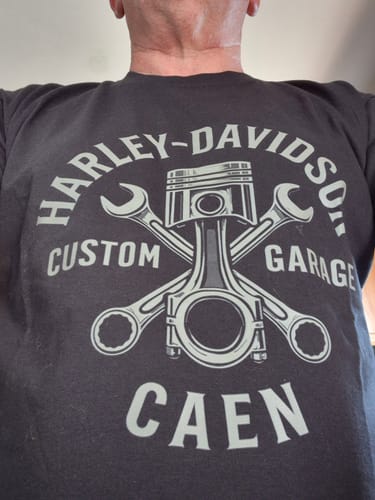Client portant le T-shirt Custom Garage noir, montrant le grand imprimé 'Harley-Davidson Caen'.