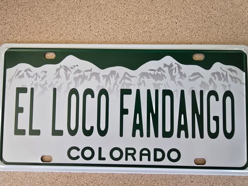 Customer's custom Colorado Metal License Plate with 'EL LOCO FANDANGO' text over a green mountain graphic.