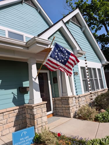 Customer's America 250 Collector's Edition Betsy Ross Flag flying on a flagpole attached to their house.