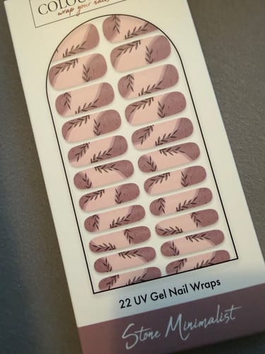 Rezensent zeigt die Verpackung der 'Stone Minimalist' UV-Gel-Nagelfolien mit schönem Blattmotiv.