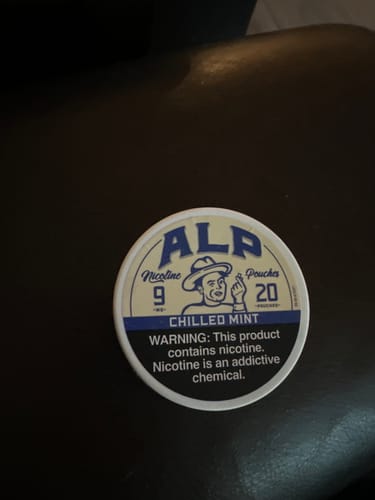 Customer's can of Chilled Mint Nicotine Pouches resting on a dark surface.