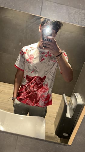 Client prenant un selfie dans le miroir en portant le maillot spécial du Brésil, blanc avec un motif rouge.