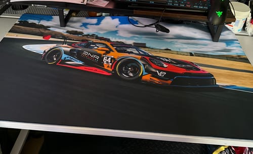 Customer's large iD Mammoth mousepad with a custom print of a racing car on a track, covering their desk.