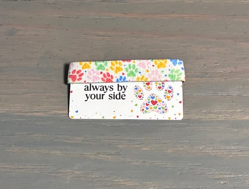 Reviewer's Always By Your Side Bracelet with a colorful paw print band on its backing card.