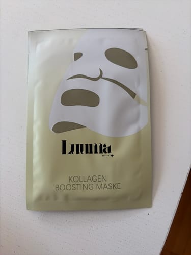 Ein Kunde zeigt die goldfarbene Verpackung der Kollagen Boosting Maske.