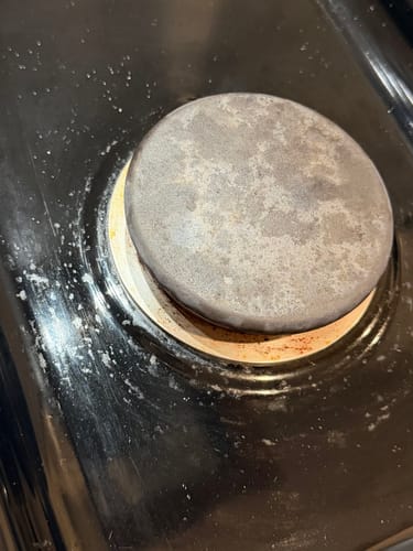 Reviewer's close-up of a greasy, splattered stovetop before using the Multi-Surface Concentrate.