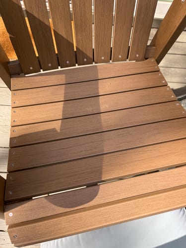 Customer's close-up of scratches and marks on the seat of the brown Counter Height Bistro Tete-a-tete chair.