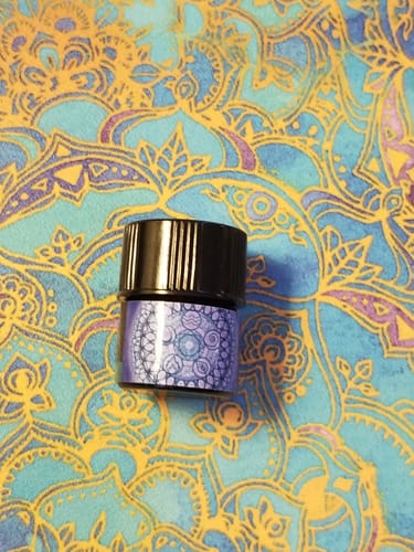 Customer's bottle of Air perfume on a colorful, patterned background.
