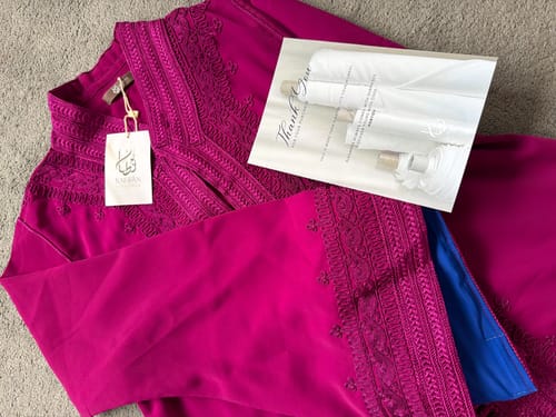 Customer's magenta Caftan Nazeera laid out, showing the detailed embroidery on the collar and sleeves.