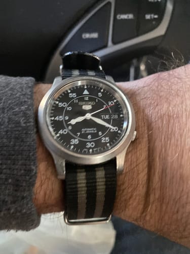 Customer wearing the black and gray striped Original - Bond watch strap on their wrist.