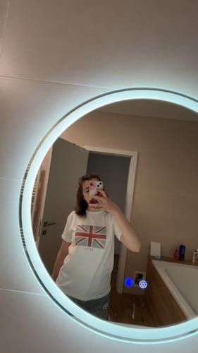 Reviewer wearing the white union jack baby tee in a mirror selfie.