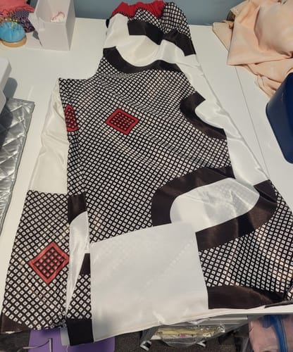 Customer shows patterned fabric from the bundle cut into pieces for wide trousers, with a white satin lining.