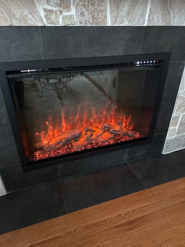 Customer's Modern Flames Redstone Electric Firebox insert installed in a wall with dark tiles, displaying glowing orange flames.
