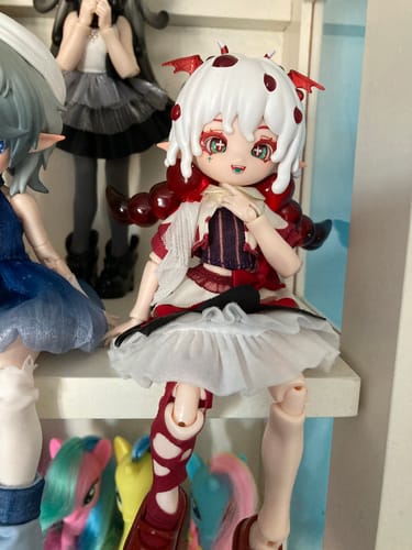 Reviewer's Mogo Bloom Hydnellum Peckii action figure sitting on a white shelf among other dolls.