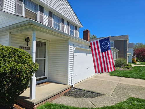 Customer's 1776 to 2026 Betsy Ross Flag mounted and flying on the front of a home.