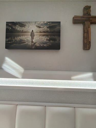 Customer's Walking on Water faith wall art displayed on a wall next to a decorative wooden cross.