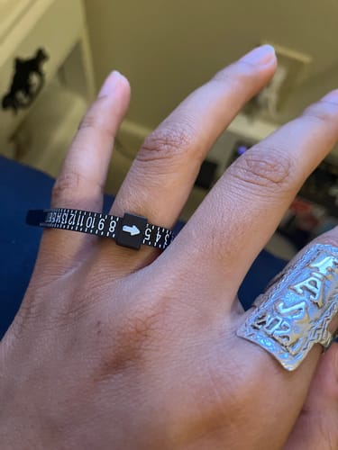 Reviewer measuring their finger with the black plastic Free Ring Sizer.