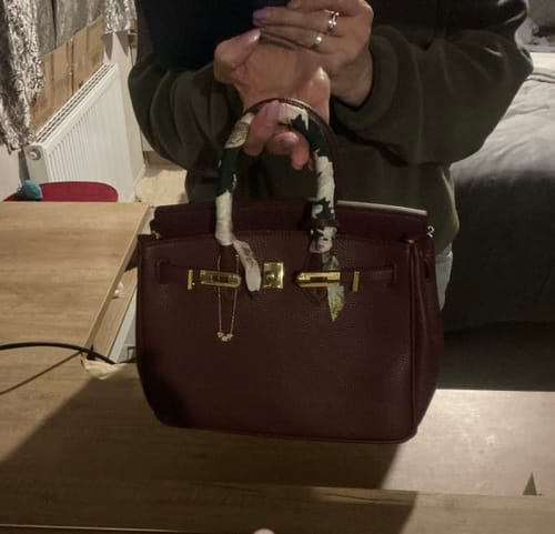 Customer holding their wine-colored LALUVA Warkin Bag with a patterned scarf wrapped around the top handle.