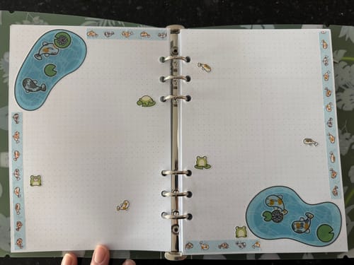 Customer's planner decorated with koi pond, fish, and frog stickers from the Calm Koi Pond Variety Sticker Pack.