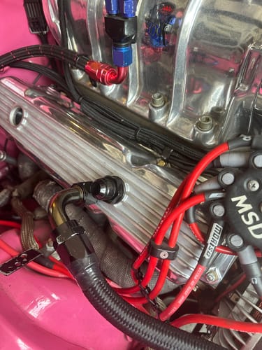 Close-up of a customer's black SBC 12AN Valve Cover Adapter Fitting installed on a shiny chrome valve cover.