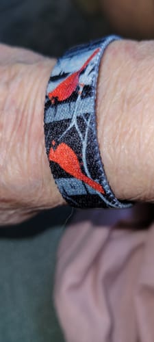 Customer's close-up of the Angels Are Near Bracelet on their wrist, showing the red cardinal pattern.